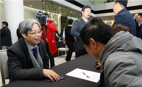 沈伯明委员（左）参加市政协全会现场咨询活动